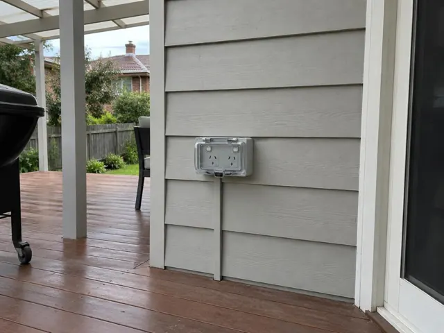 Outdoor power point on weatherboard wall beside a timber deck in Waitara